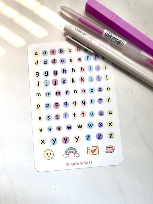 A sheet of pastel alphabet stickers with small emoji by Simple & Soft Studio